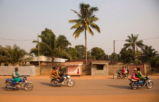 People ride motorcycles through the streets of Bangui.